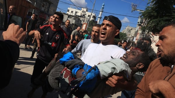 A man helps move a wounded man to safety after Israeli bombardment in Rafah in southern Gaza