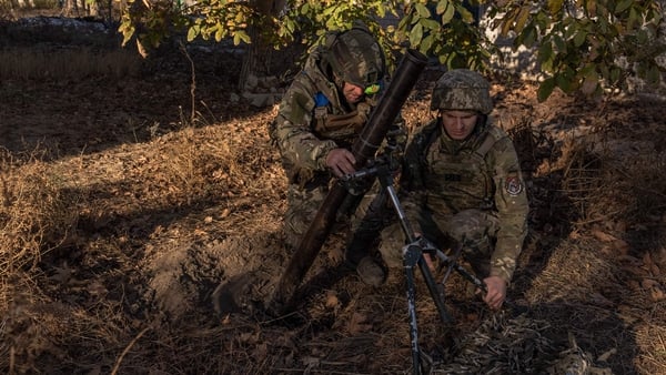 Ukrainian servicemen of the 123rd Territorial Defence Brigade prepare to fire a mortar over the Dnipro River toward Russian positions